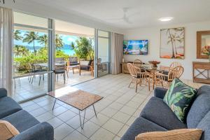 a living room with a couch and a table and chairs at Whitsunday Apartments on Hamilton Island by HIHA in Hamilton Island