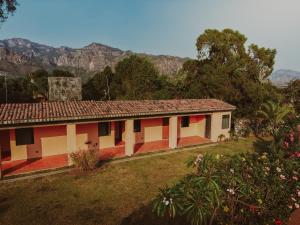 a red and white house with mountains in the background at Casa Evelia in Tepoztlán