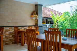 a dining room with a wooden table and chairs at Wana Kubu Suite and Dormitory in Ngurah Rai International Airport