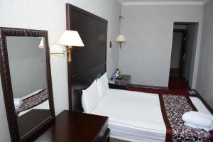 a hotel room with a bed and a mirror at White House Hotel in Ulaanbaatar