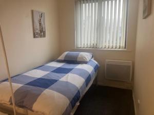 a bedroom with a blue and white bed in a room at Lavender Cottage in Thirsk