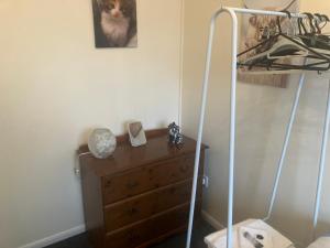 a room with a dresser with a cat on the wall at Lavender Cottage in Thirsk