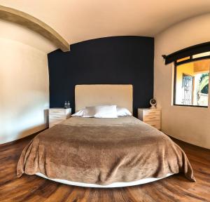a bedroom with a large bed and a black wall at Casa Evelia in Tepoztlán