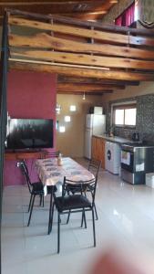 a dining room with a table and chairs in a kitchen at Cabaña Mitimay in Alta Gracia
