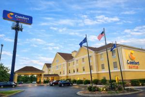 a front view of a hotel with flags in a parking lot at Comfort Suites Scranton near Montage Mountain in Scranton