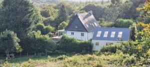a white house with a blue roof on a hill at Au Pré du Chêne in Le Faouët