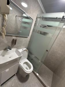 a bathroom with a toilet and a sink and a mirror at Sarrafon Guest House in Bukhara