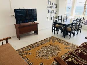 a living room with a tv and a table and chairs at Virtus home stay in Pondicherry