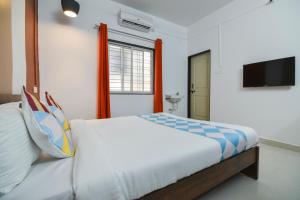 a bedroom with a bed and a tv on the wall at HOTEL O THE G STAY in Chinchwad