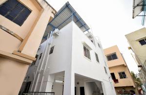 a white building with a window on the side of it at HOTEL O THE G STAY in Chinchwad