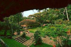 a view of a house with a grass roof at Spice Village Thekkady - A CGH Earth Experience in Thekkady +53 photos