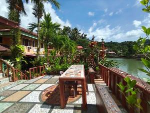 a wooden table on a bridge near a body of water at Stefanie Grace Inn in Loboc