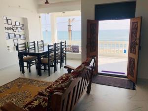 a dining room with a table and chairs and the ocean at Virtus home stay in Pondicherry