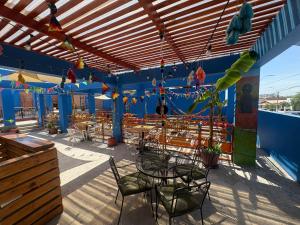 a patio with tables and chairs and a blue wall at Raymi House Hostel in Arica
