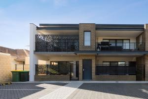 a brick house with a balcony and a door at 9 by the Beach in Rockingham