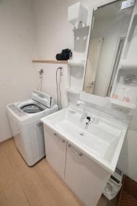 a white bathroom with a sink and a mirror at 舒爽旅馆 in Fuefuki +34 photos