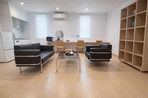 a living room with two black chairs and a table at 舒爽旅馆 in Fuefuki