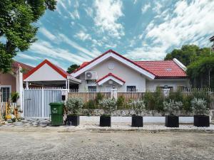 a white house with a fence in front of it at Soak Screen Urban Hideaway in Iloilo City