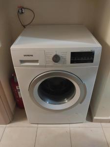 a white washing machine sitting in a room at Ζ Luxury near Airport in Thessaloniki +8 photos