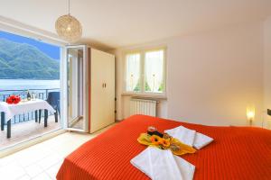 a bedroom with a red bed with a view of the ocean at Villa L'Approdo in Porlezza +18 photos