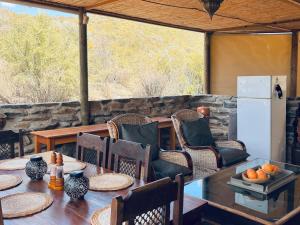 a dining room with a table and chairs and a refrigerator at Tula Retreat - Secluded Karoo Escape - Hot Tub - Private Boat Arrival in Calitzdorp
