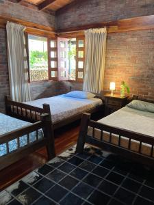 a bedroom with two beds and a brick wall at Morada de las Aves in Cali