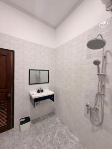 a white bathroom with a sink and a shower at Sunin Hotel Dondet Riverside in Don Det