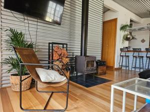 a living room with a chair and a wood stove at Cedar Hill Retreat in Venus Bay