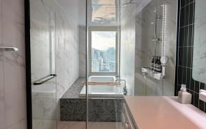 a bathroom with a shower and a tub with a window at Hyoi Stay Busan Songdo in Damyang +59 photos