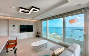 a living room with a view of the ocean at Hyoi Stay Busan Songdo in Damyang