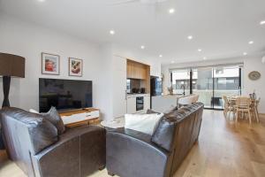 a living room with two leather chairs and a table at Williamstown Townhouse in Williamstown