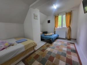 a small bedroom with two beds and a window at Diana's Holiday Home in Podu Dîmboviţei