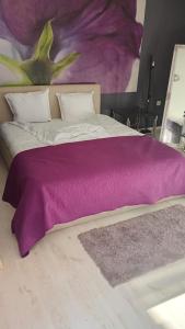 a bed with a purple blanket on top of it at Кичук Париж in Plovdiv
