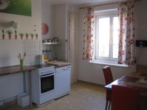 a kitchen with white appliances and a table and a window at Appartement St. Leonhard in Graz