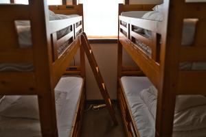 a group of bunk beds in a room with a window at IZA Kamakura Guest House and Bar in Kamakura +36 photos