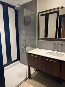 a bathroom with a sink and a glass shower at Wish Inn Silom - Decho Bangkok City in Bang Rak