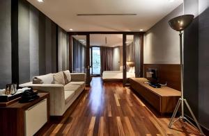 a living room with a couch and a bed at Wish Inn Silom - Decho Bangkok City in Bang Rak +24 photos