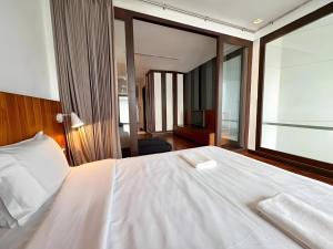 a bedroom with a white bed and a large window at Wish Inn Silom - Decho Bangkok City in Bang Rak