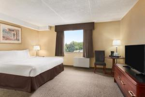 a hotel room with a bed and a flat screen tv at Days Inn by Wyndham Fallsview in Niagara Falls