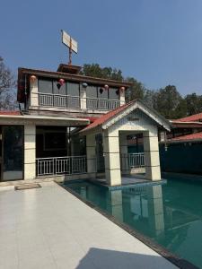 a building with a swimming pool in front of it at Celebrations Party House in Kolhapur