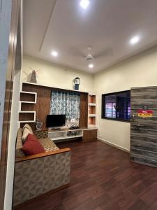 a living room with a couch and a flat screen tv at Celebrations Party House in Kolhapur