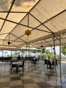a restaurant with tables and chairs under a tent at Celebrations Party House in Kolhapur