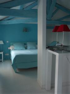 een blauwe slaapkamer met een bed en een rode lamp bij Hôtel du Palais in Angoulême