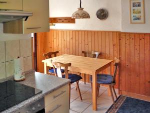 a kitchen with a wooden table and chairs in it at Luzie's Hus in Freest