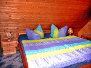 Schlafzimmer mit einem Bett mit blauen und gelben Kissen in der Unterkunft Luzie's Hus in Freest