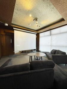 a room with two couches and a projection screen at 台町Arun別邸 in Abashiri