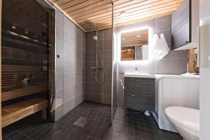 a bathroom with a shower and a sink and a toilet at UnelmaPovi in Ruka