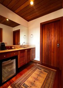 a kitchen with wooden cabinets and a kitchen rug at Hortênsia Boutique - Chalés de Luxo & Suítes Privativas in Campos do Jordão