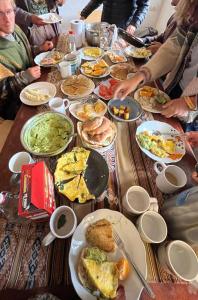 a long table filled with plates of breakfast food at Maska Mystic Tribe - Community Life in Pisac