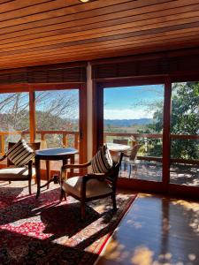 a large screened in porch with a table and chairs at Hortênsia Boutique - Chalés de Luxo & Suítes Privativas in Campos do Jordão